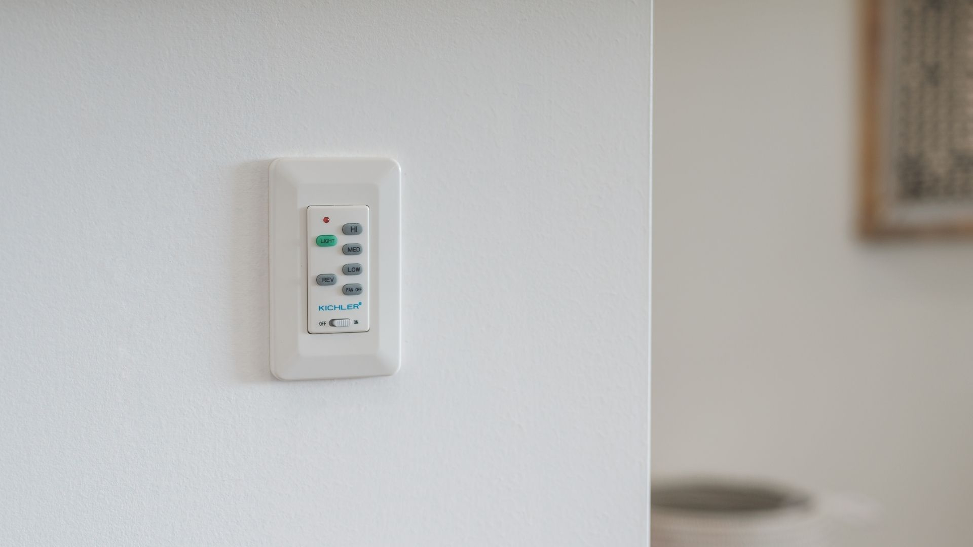 White wall-mounted Kichler light and fan remote control.