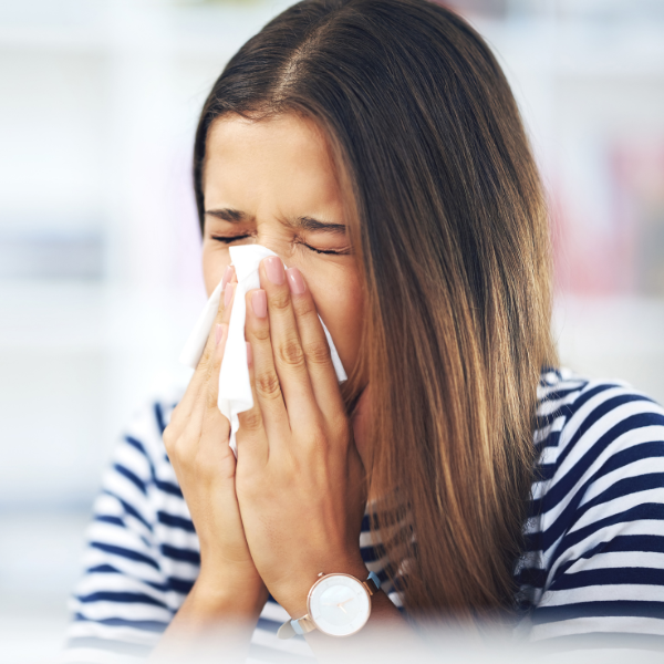 woman sneezing into tissue