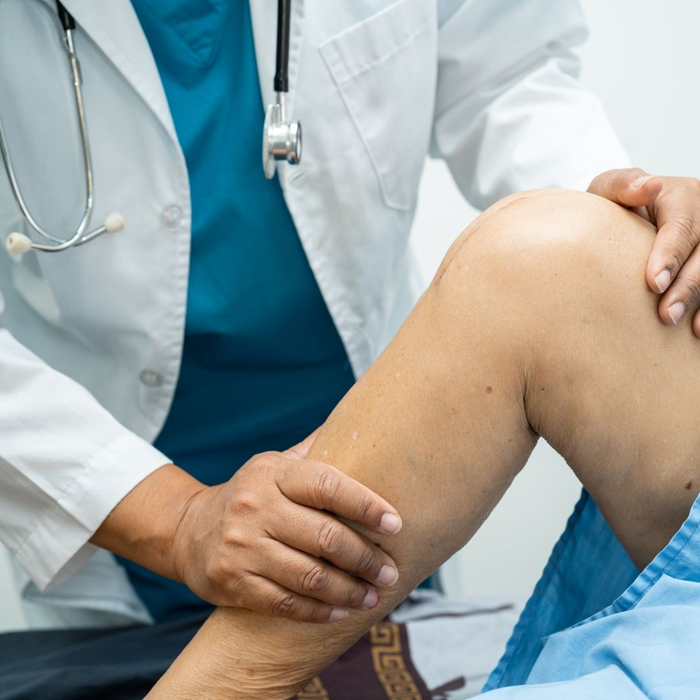 doctor feeling a person's leg
