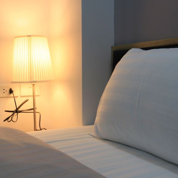 Lamp next to a bed. 