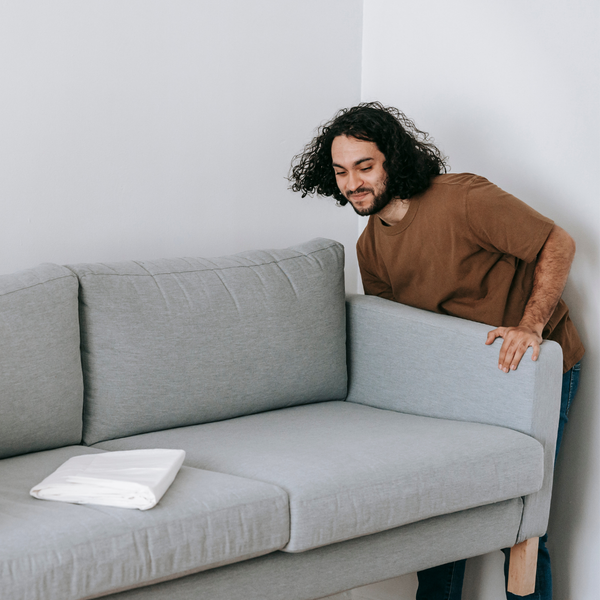 Two people moving a couch.
