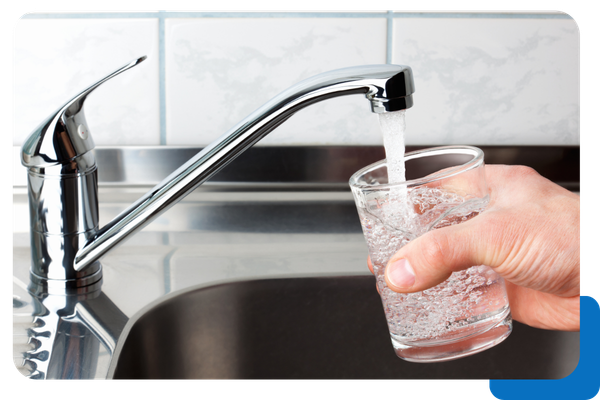 person getting water from faucet