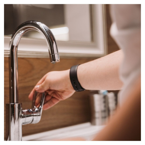 woman turning on kitchen faucet