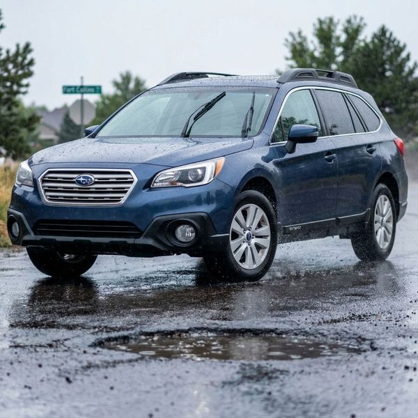 a car on the road in wet weather where the tires are turned slightly