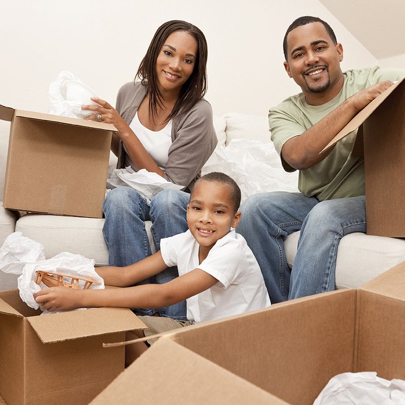 family sitting next to moving boxes