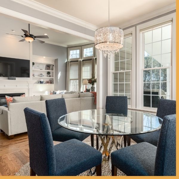 Modern crystal pendant chandelier over a dining table and ceiling fan in living room