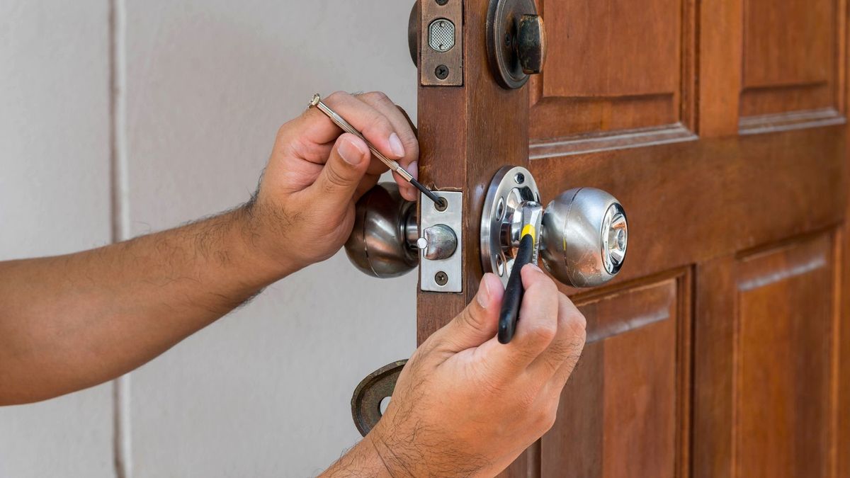 A locksmith installing a new lock on a front door
