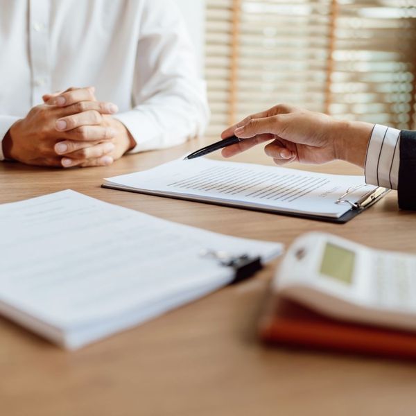 insurance advisor pointing at clipboard with pen 