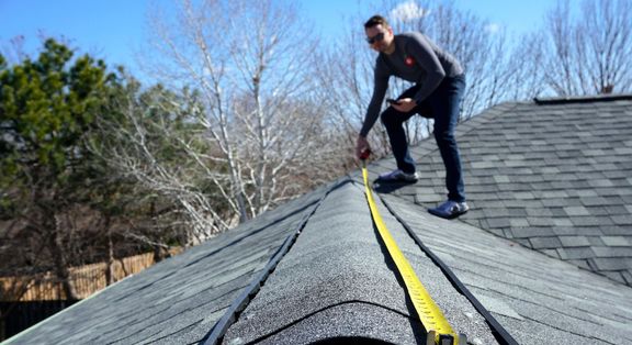 a person measures a section of roof 