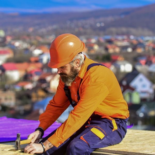 a roofer uses a hammer 