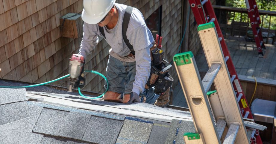 man installing asphalt roof