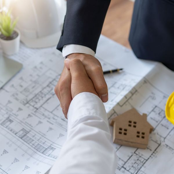 handshake over floor plans