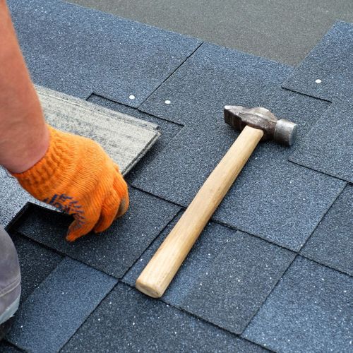 person hammering shingles