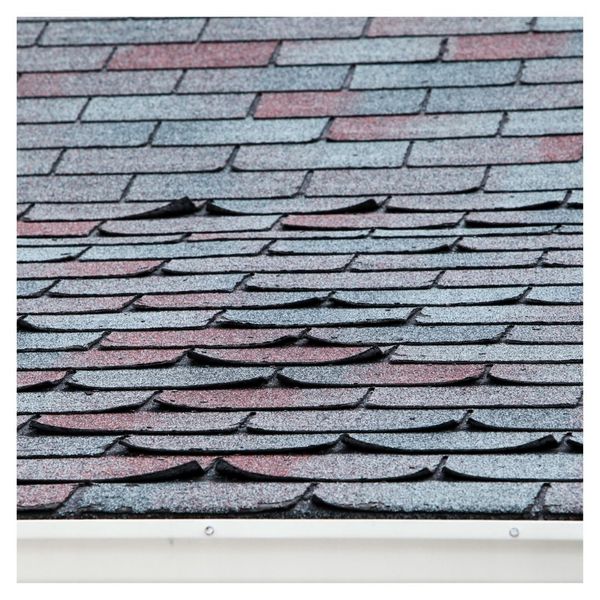 Curled and damaged shingles indicating roof wear and aging