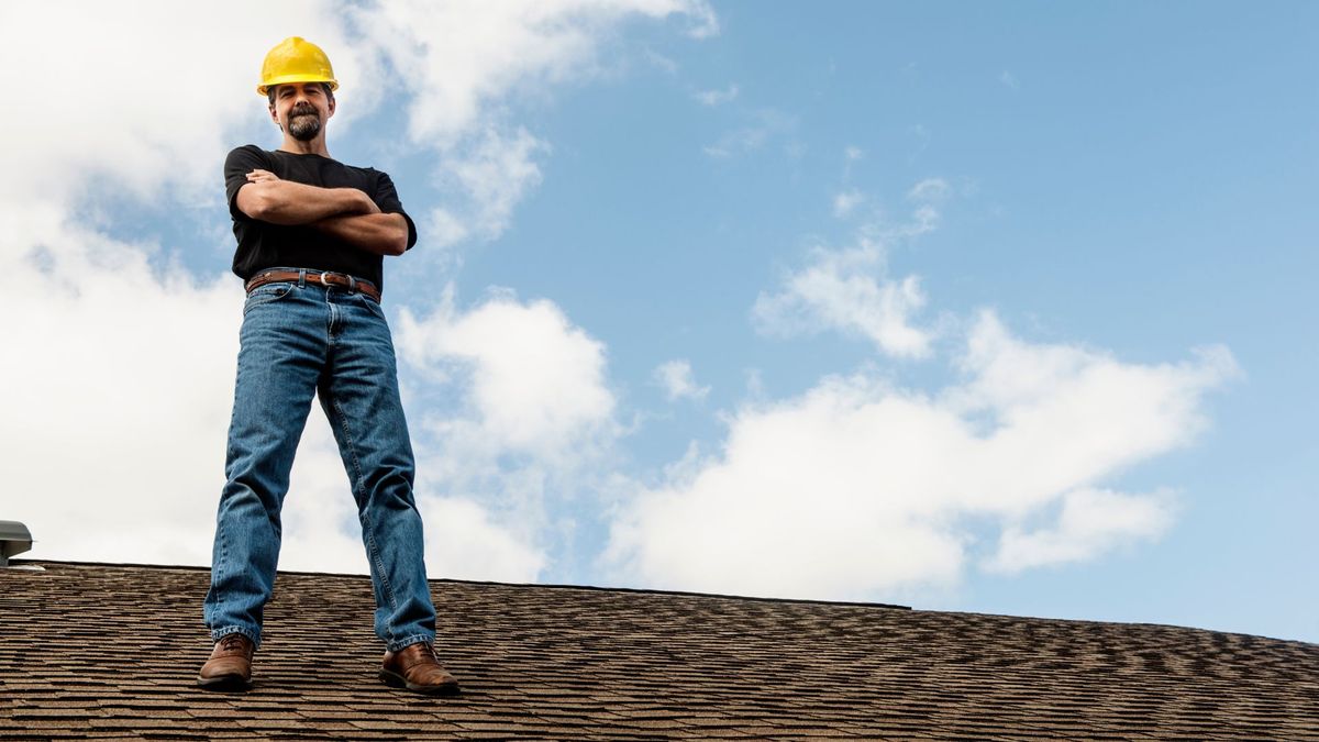 roofing contractor standing on roof