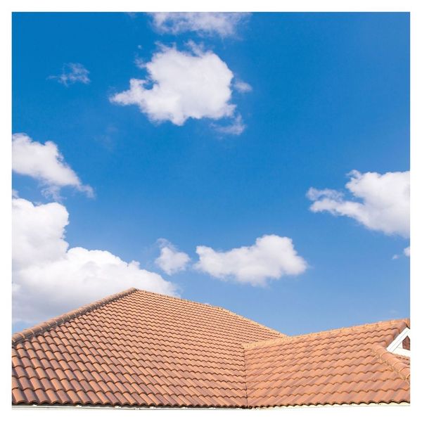 A house with terracotta roof tiles under a clear blue sky