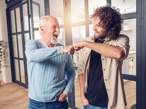 older man and younger man doing a fist bump