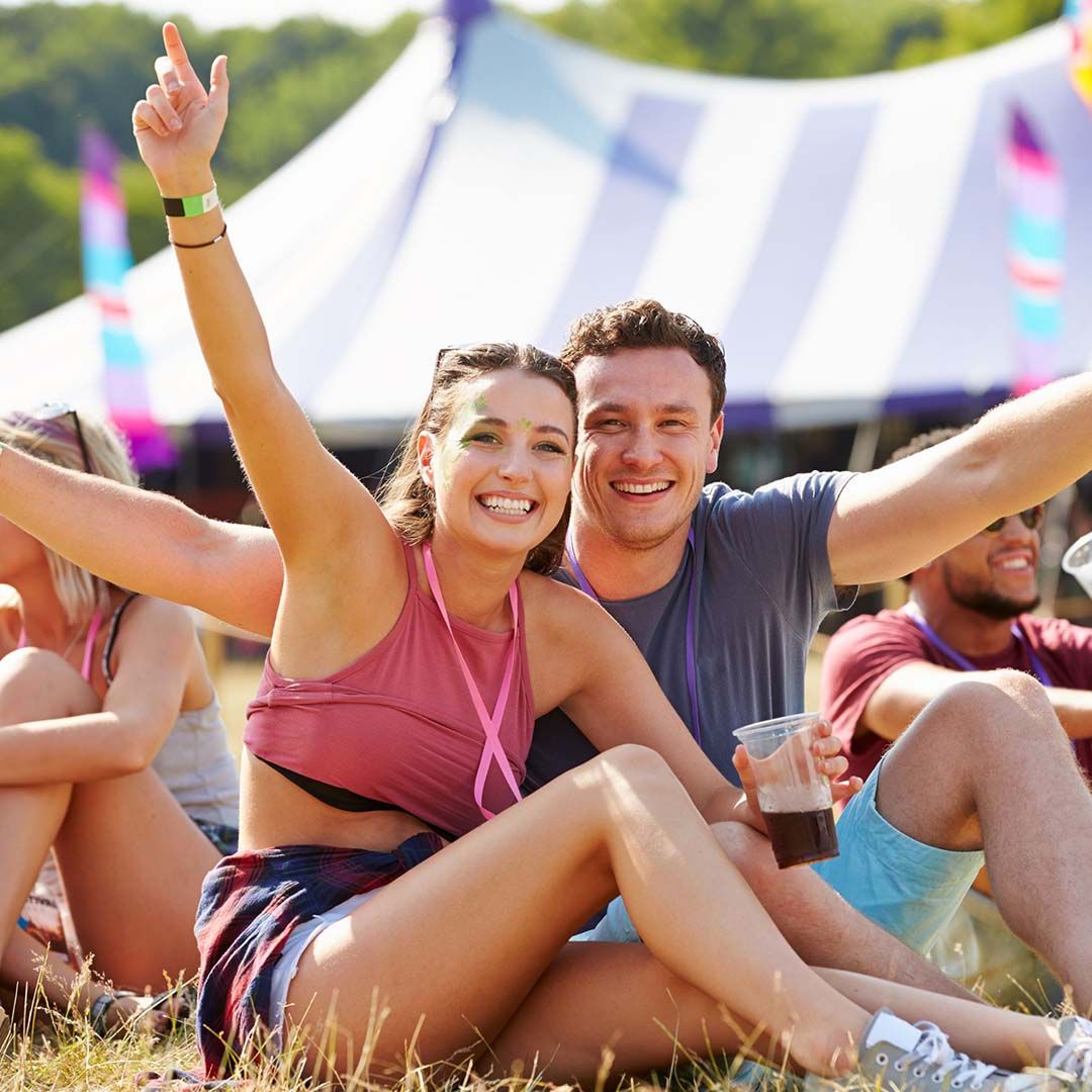 happy couple at festival with arms up