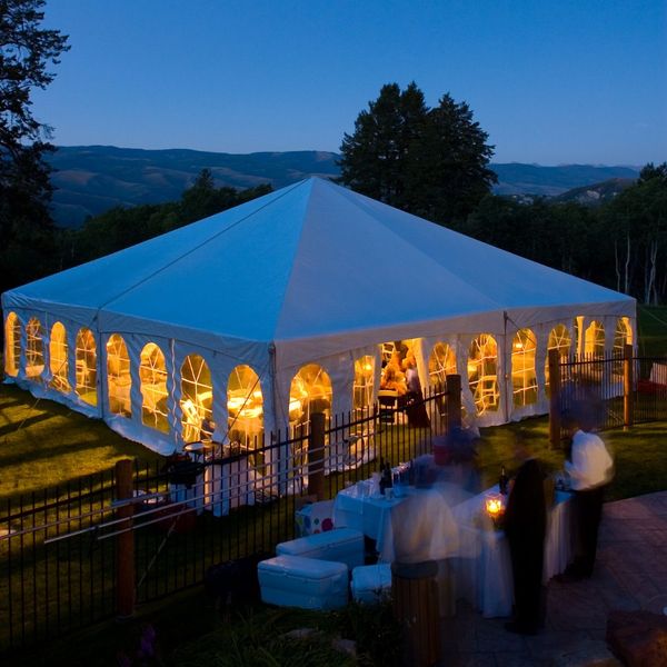 large tent at dusk with lights on inside