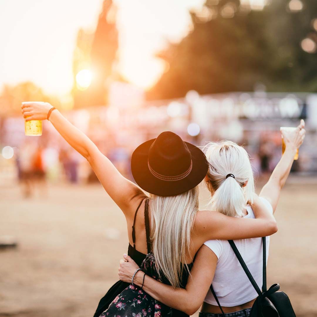 two women at festival holding drinks up