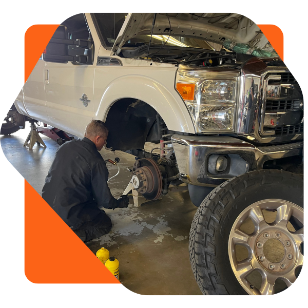 Image of a mechanic working on the breaks of a pickup truck