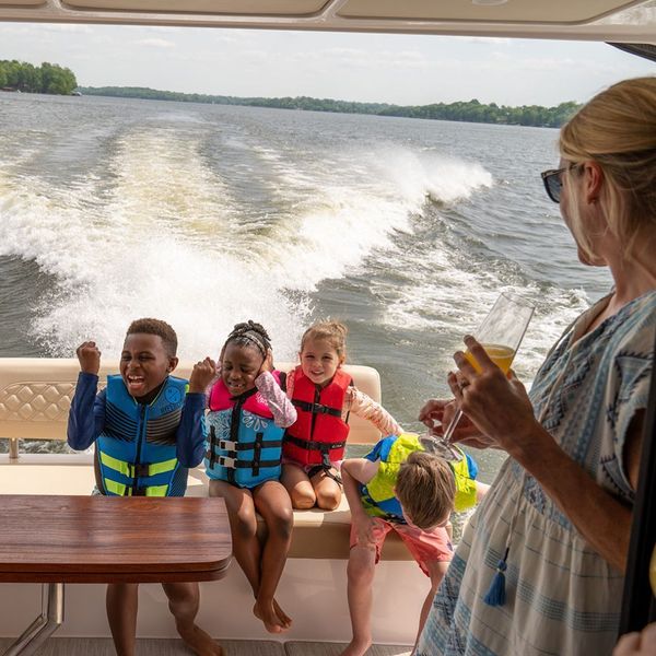 Kids in the back of a boat with parent looking on