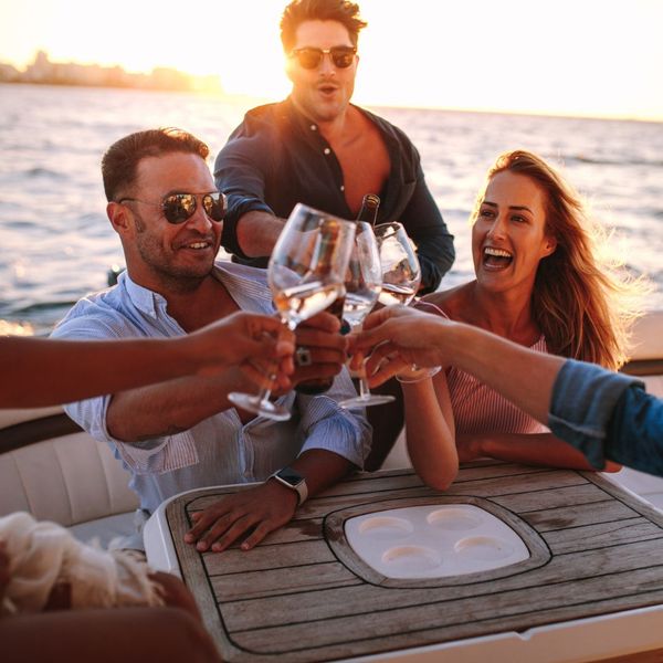 friends cheering glasses on yacht