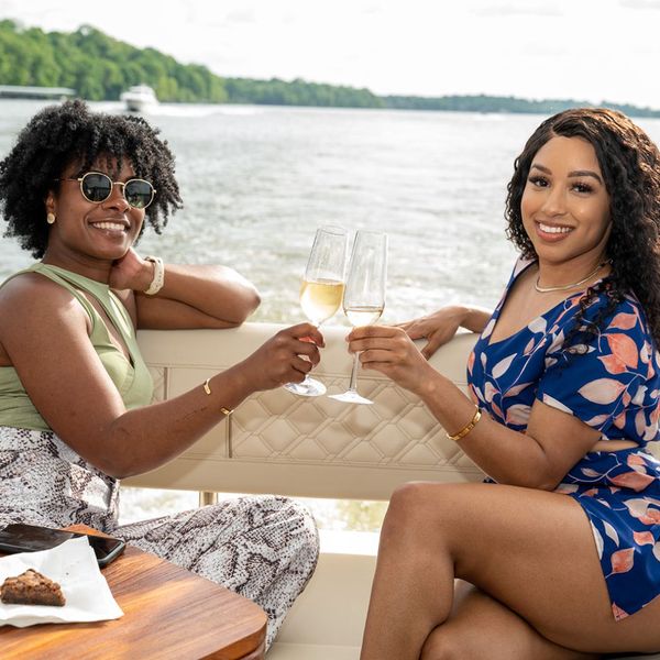 Two women with drinks and desserts