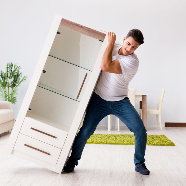 Man tries to move heavy dresser on his own