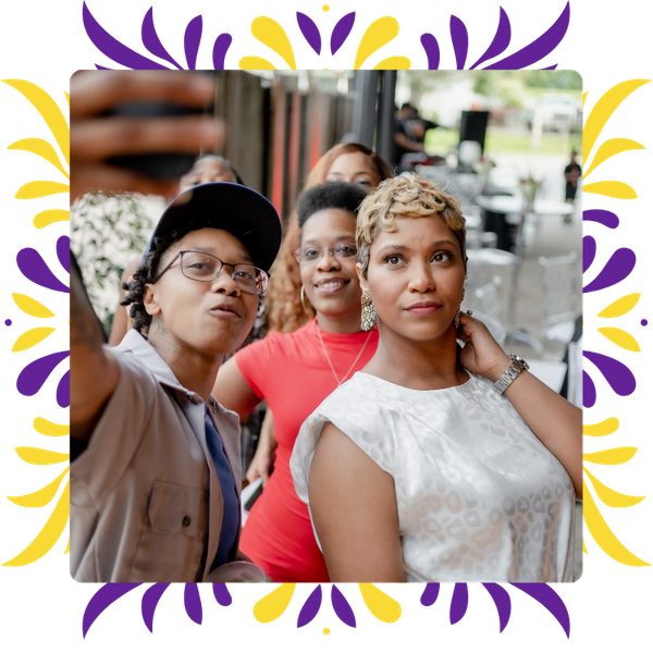 Three diverse guests smiling and taking a selfie together, capturing a fun moment during a lively retirement celebration