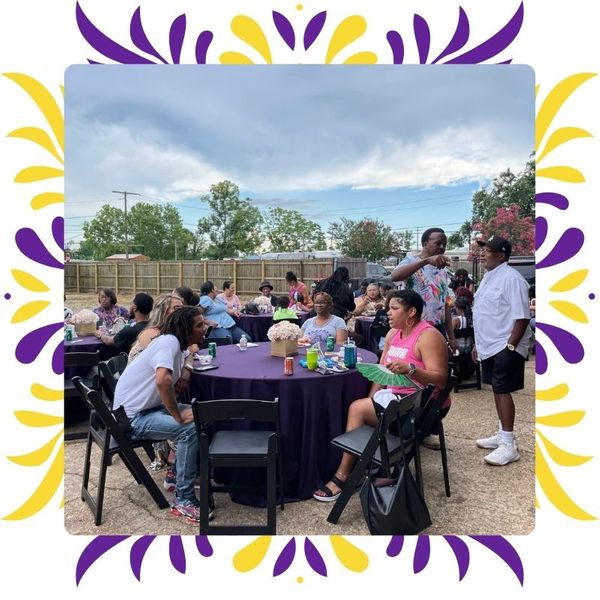 Guests seated at purple-covered tables under a cloudy New Orleans sky, celebrating a retirement party