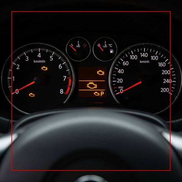A car's dashboard with the check engine light illuminated. A car's dashboard with the check engine light illuminated.