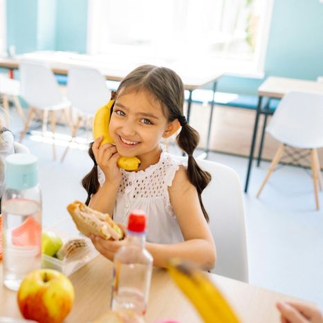 child pretending banana is a phone at lunch