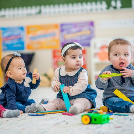 Three infants playing with toys. 