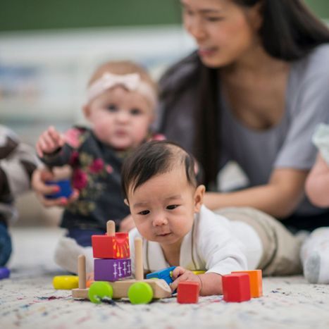 an infant playing with blocks while laying on it's stomach