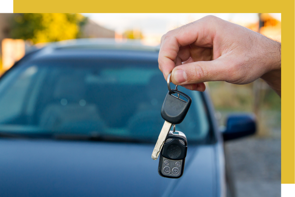 holding car keys in front of car