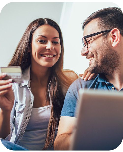 man and woman smiling with credit card in hand