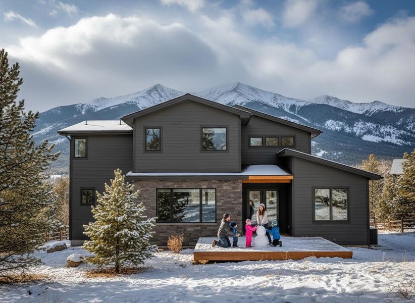 Family building snowman at a modern home with mountain views
