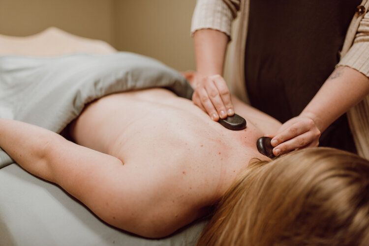 A client receiving a relaxing hot stone massage treatment at Height of Health Massage near PVH in Fort Collins