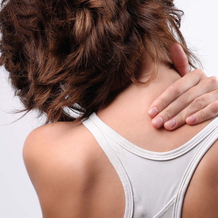 woman rubbing neck shoulder area