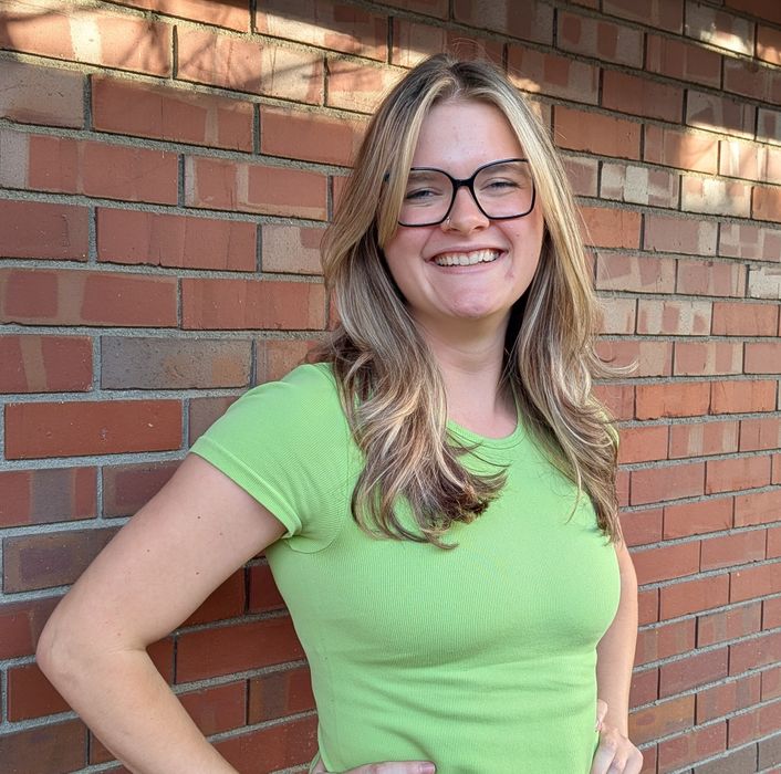 Whitley a massage therapist at Height of Health Massage posing outside of our building Our newest massage therapist in Fort Collins