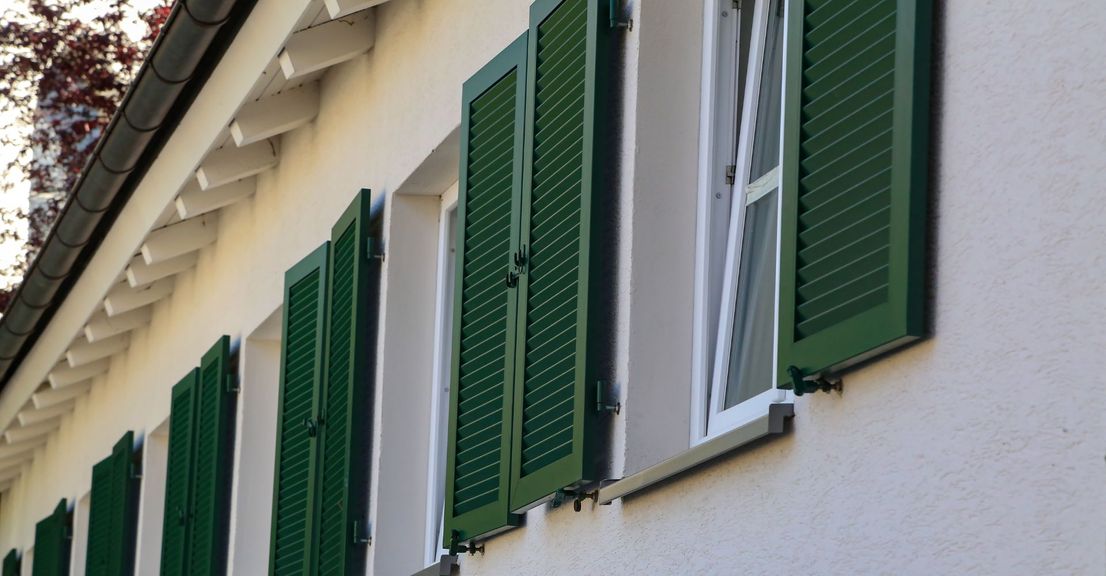 Green plantation shutters on apartment windows