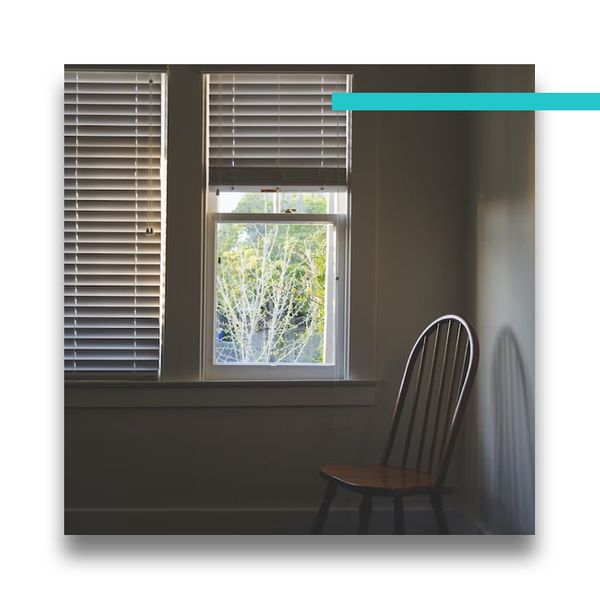 shutters on windows in a room with a chair