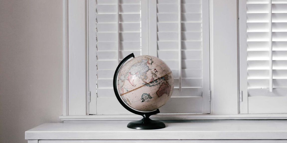 A globe in front of white shutters