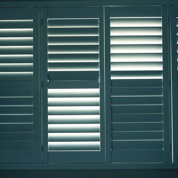 a panel of greenish blue plantation shutters