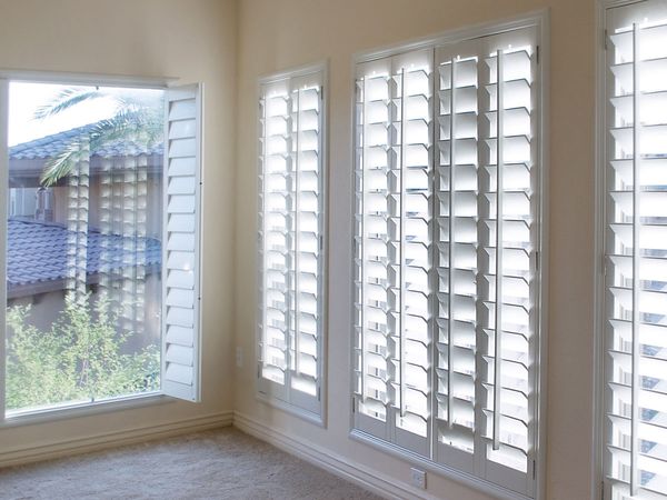 a row of tall plantation shutters in a home