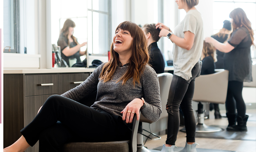 woman in salon chair laughing