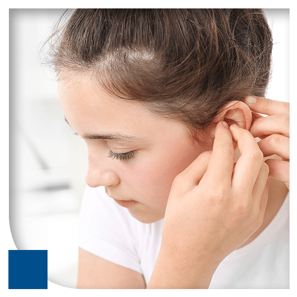 A child adjusting their small hearing aids.