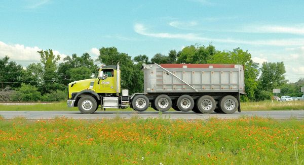 a tuck hauling a trailing by a field of flowers Blog.jpg