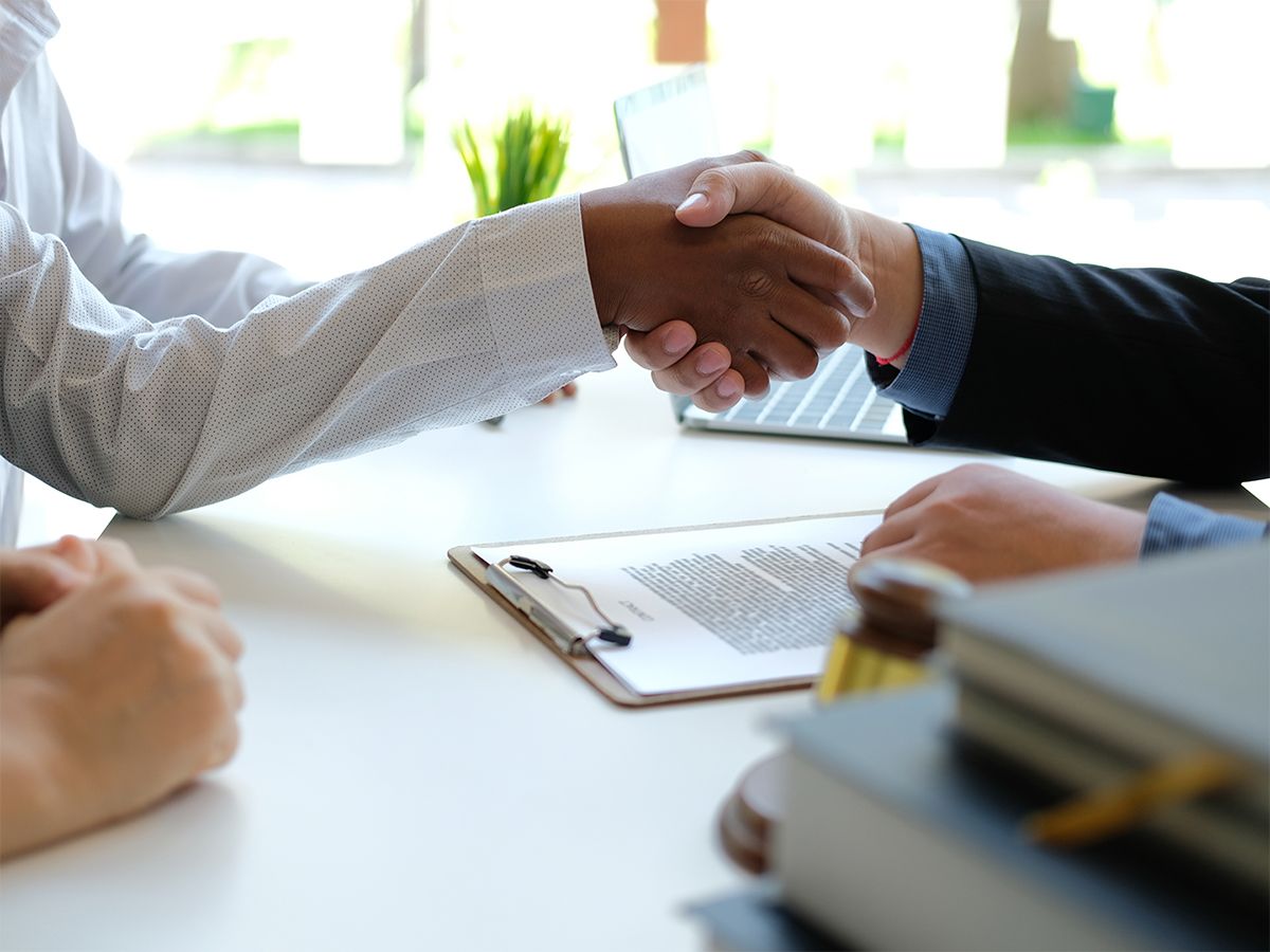 Two people shaking hands, completing a transaction.